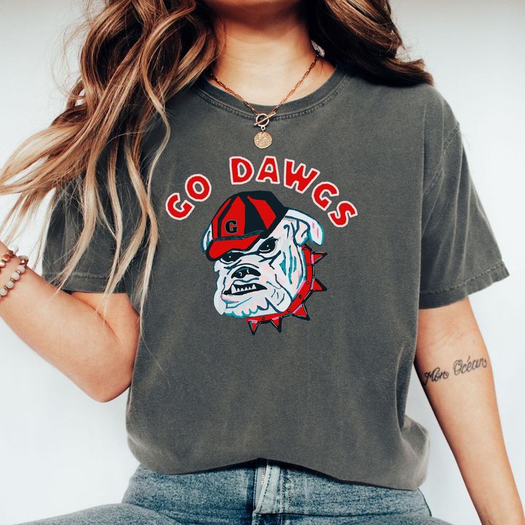 a woman wearing a t - shirt with the word go dawgs on it