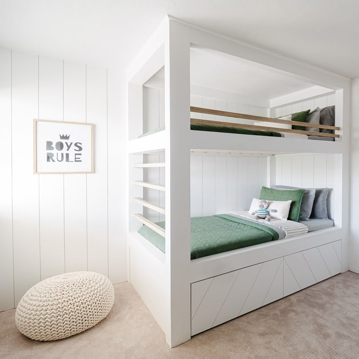 a white bunk bed with green sheets and pillows in a room that has beige carpet