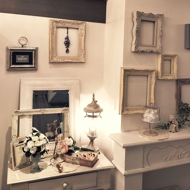 a white dresser topped with pictures and flowers