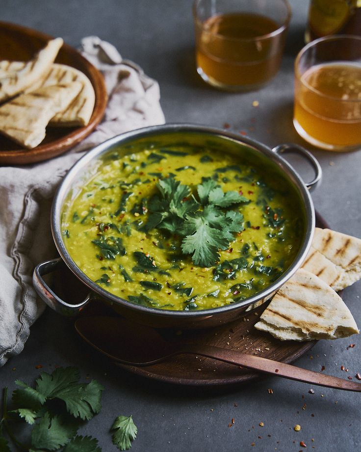 a bowl of soup with pita bread and cilantro