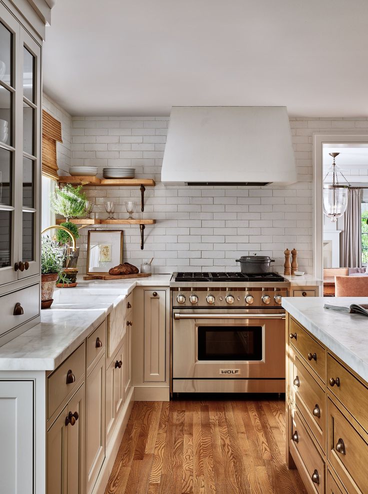 a kitchen with white brick walls and wooden cabinets, stainless steel range hood over the stove