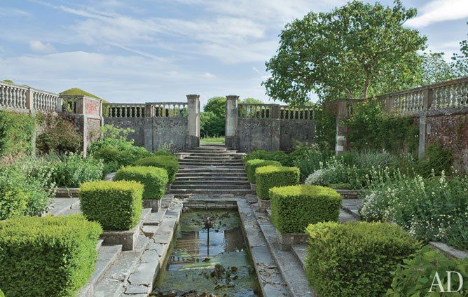 the garden is surrounded by hedges and trees