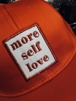 a red hat with the words more self love on it