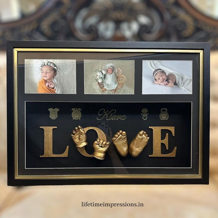 a black frame with gold lettering and photos of baby feet