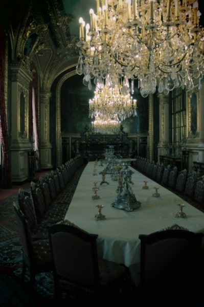 a large dining room with chandelier and table