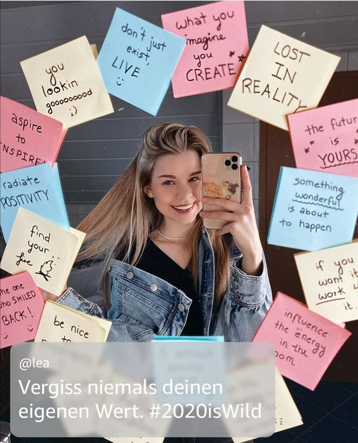 a woman taking a selfie with sticky notes on her wall and the caption says, vergis nenals deien eigern wert 2055