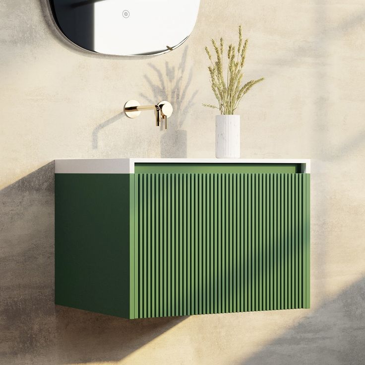 a green cabinet with a mirror above it and a plant in a vase next to it