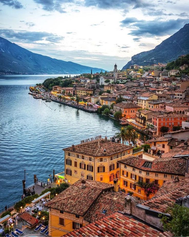 an aerial view of the town of lake garda with mountains in the back ground