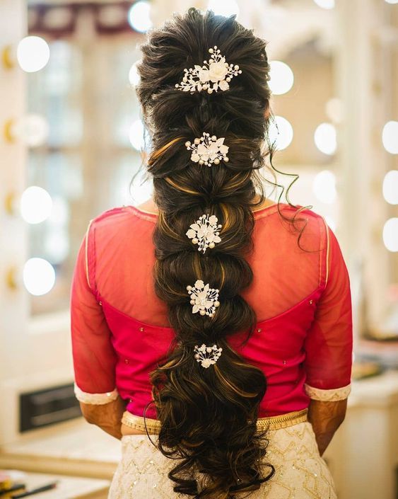 the back of a woman's head with long hair and flowers in her hair