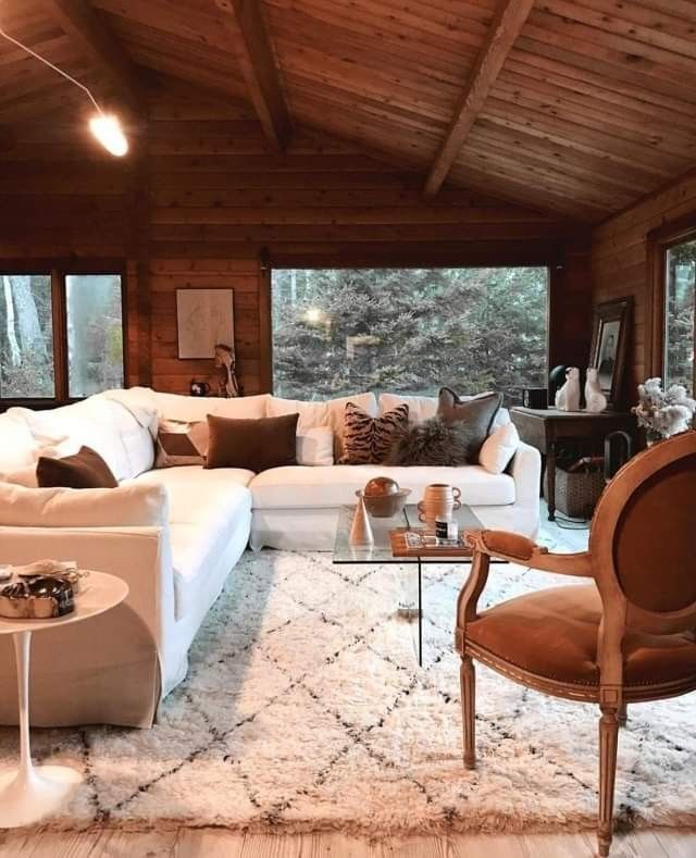 a living room filled with lots of furniture next to a large window covered in wood