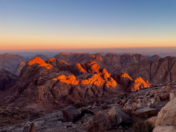 the sun is setting in the mountains with rocks and boulders on each side, as seen from above