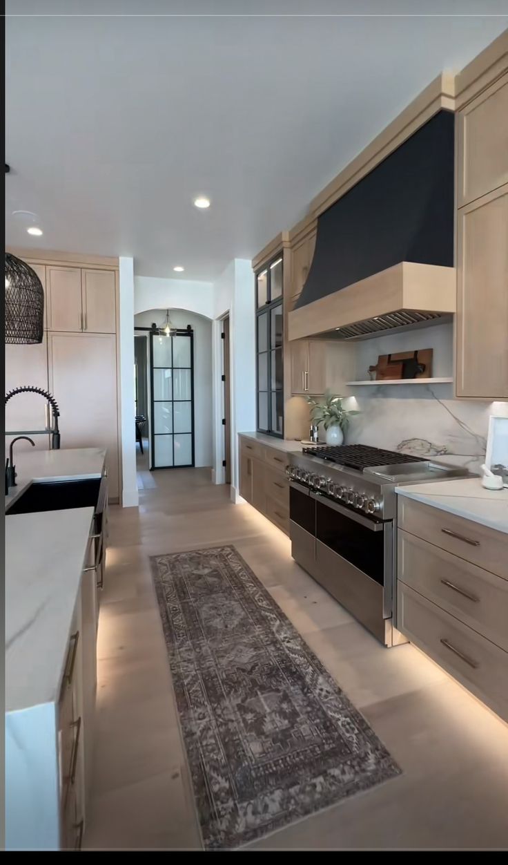 a kitchen with an oven, sink, and rug on the floor in front of it