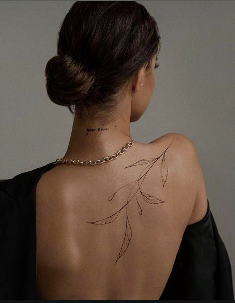 the back of a woman's neck has a tattoo on it, and is wearing a black dress