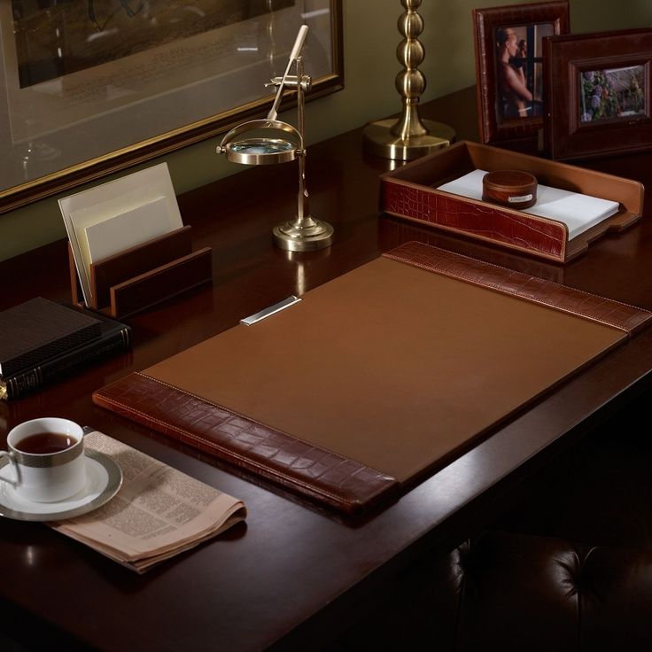 a wooden desk topped with a cup of coffee and a book on top of it