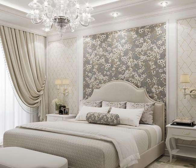 a large bed sitting in a bedroom under a chandelier next to a window