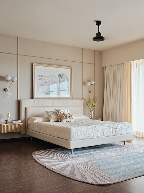 a bedroom with a bed, rug and large window in the corner that has curtains on both sides