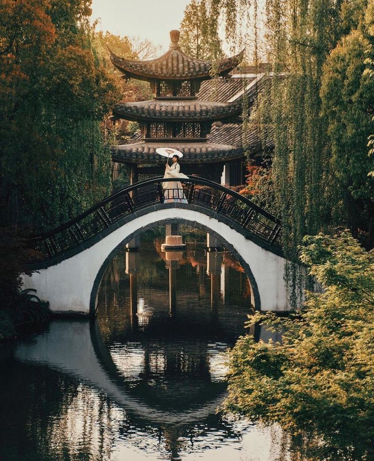 a bridge over a body of water surrounded by trees