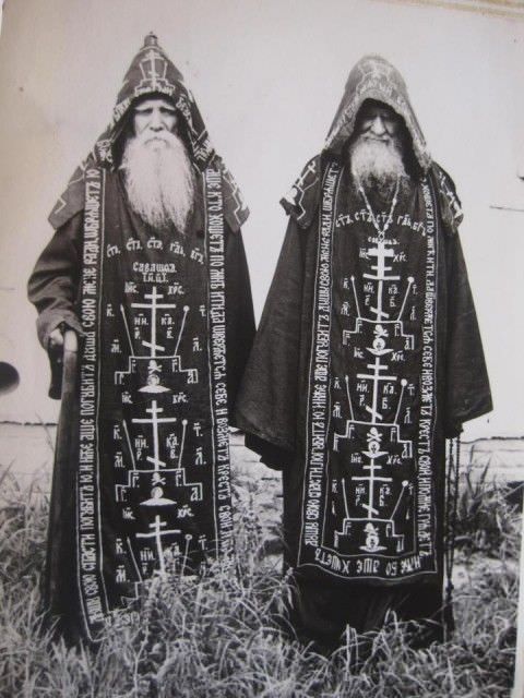 two men with long beards standing next to each other