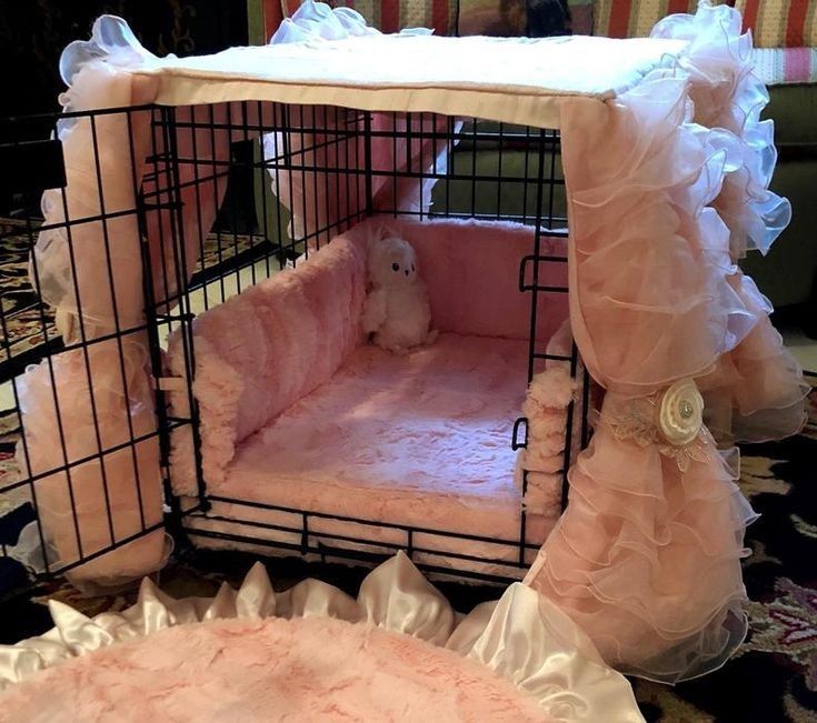 a small dog in a pink cage on the floor