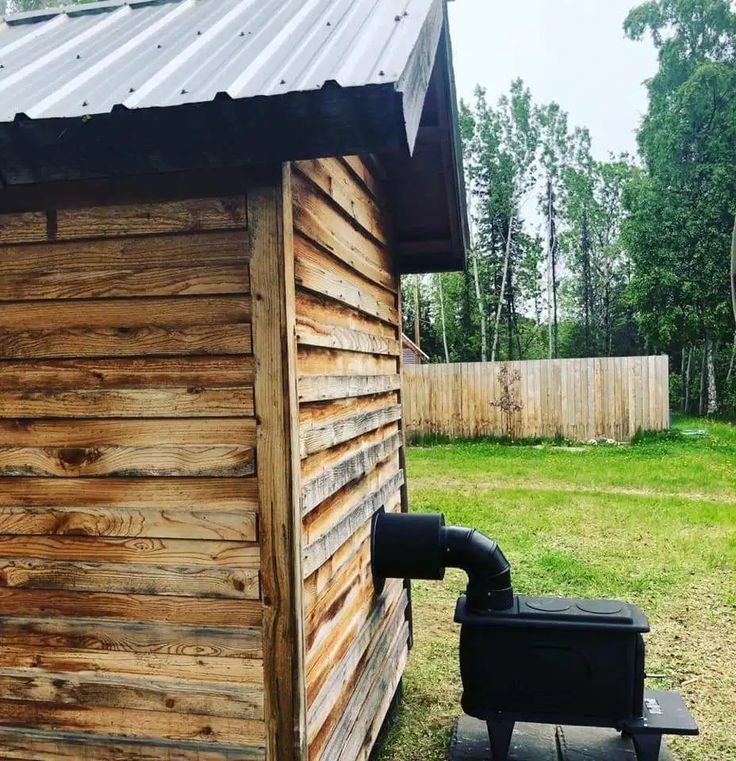 a small wooden building with a pipe on the outside