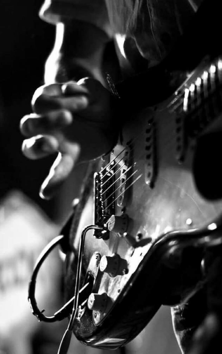 black and white photograph of a person playing an electric guitar