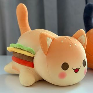 two stuffed animals that are sitting next to each other on a table, one has a sandwich in it's mouth