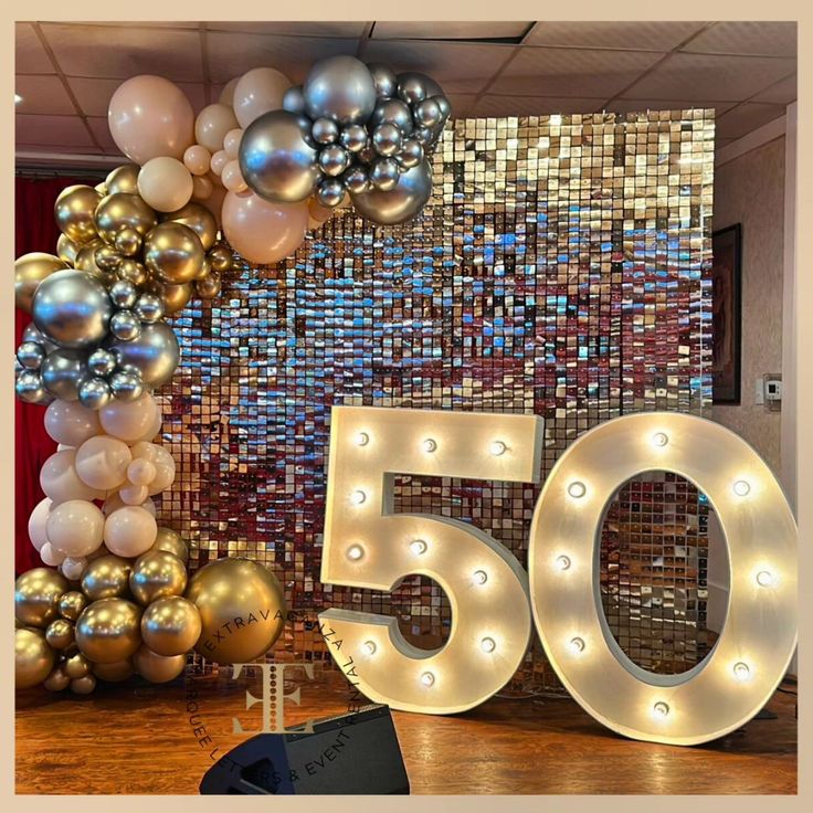 the 50th birthday sign is surrounded by balloons and streamers in gold, silver and white