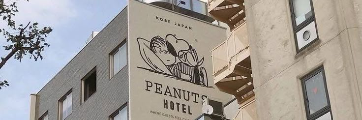 the sign for peanut's hotel is hanging from the side of an apartment building