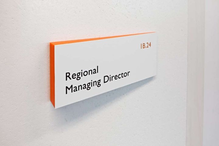 a sign that is on the side of a wall saying regional managing director in orange and white