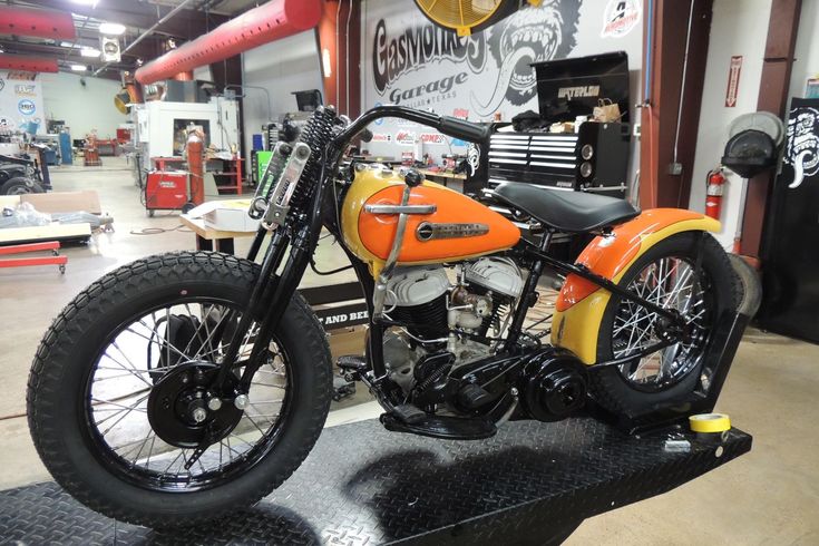 an orange and black motorcycle on display in a shop