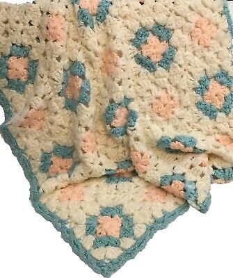 two crocheted afghans with pink and blue flowers on the edges, one is folded