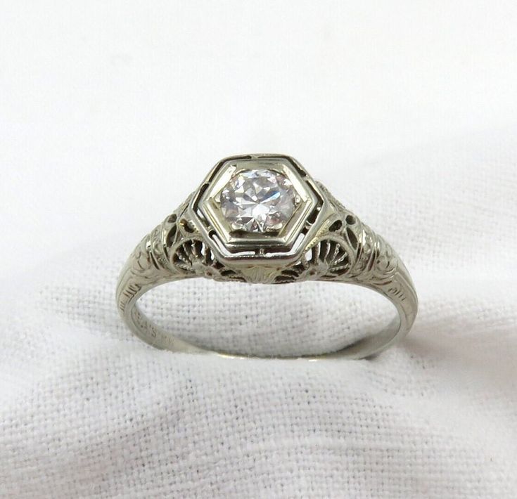 an antique style diamond ring with filigree accents