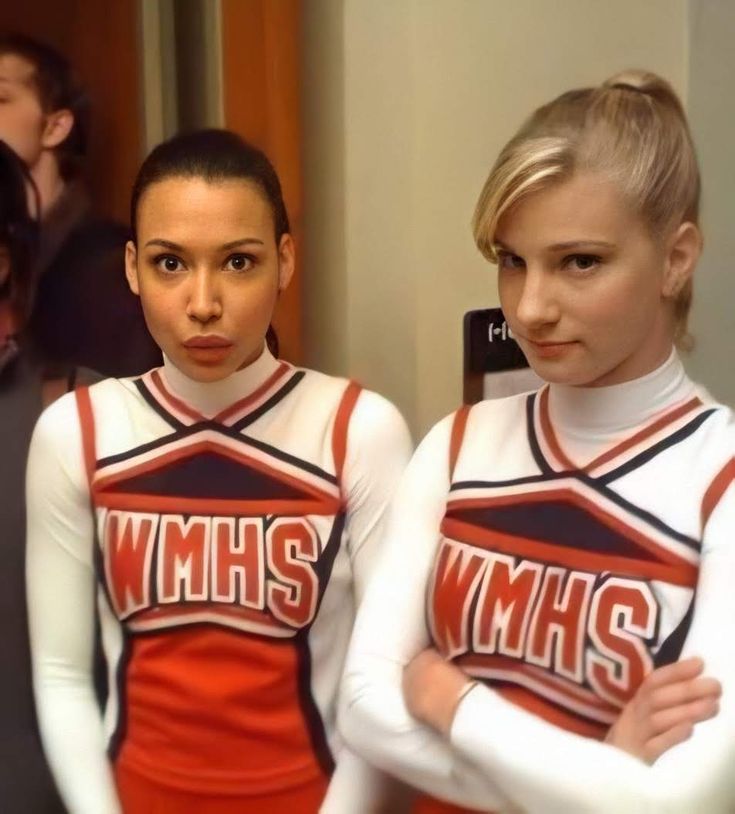 two young women in cheer uniforms standing next to each other