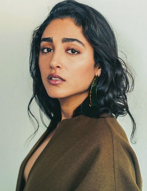 a woman with dark hair and large earrings