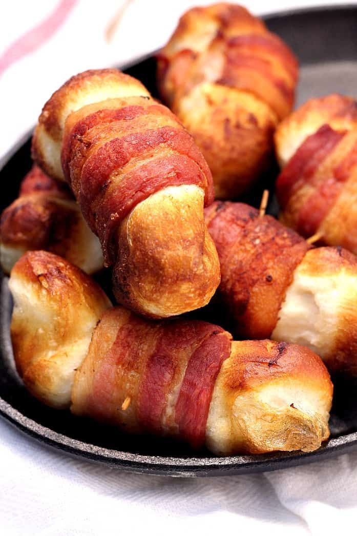 bacon wrapped hot dogs in a cast iron pan