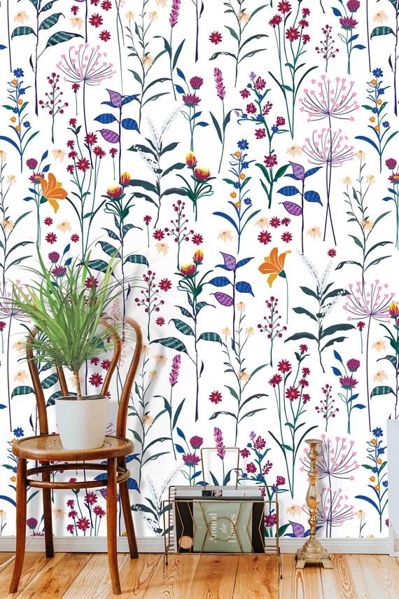 the wallpaper in this room is painted with colorful flowers and plants on white paper