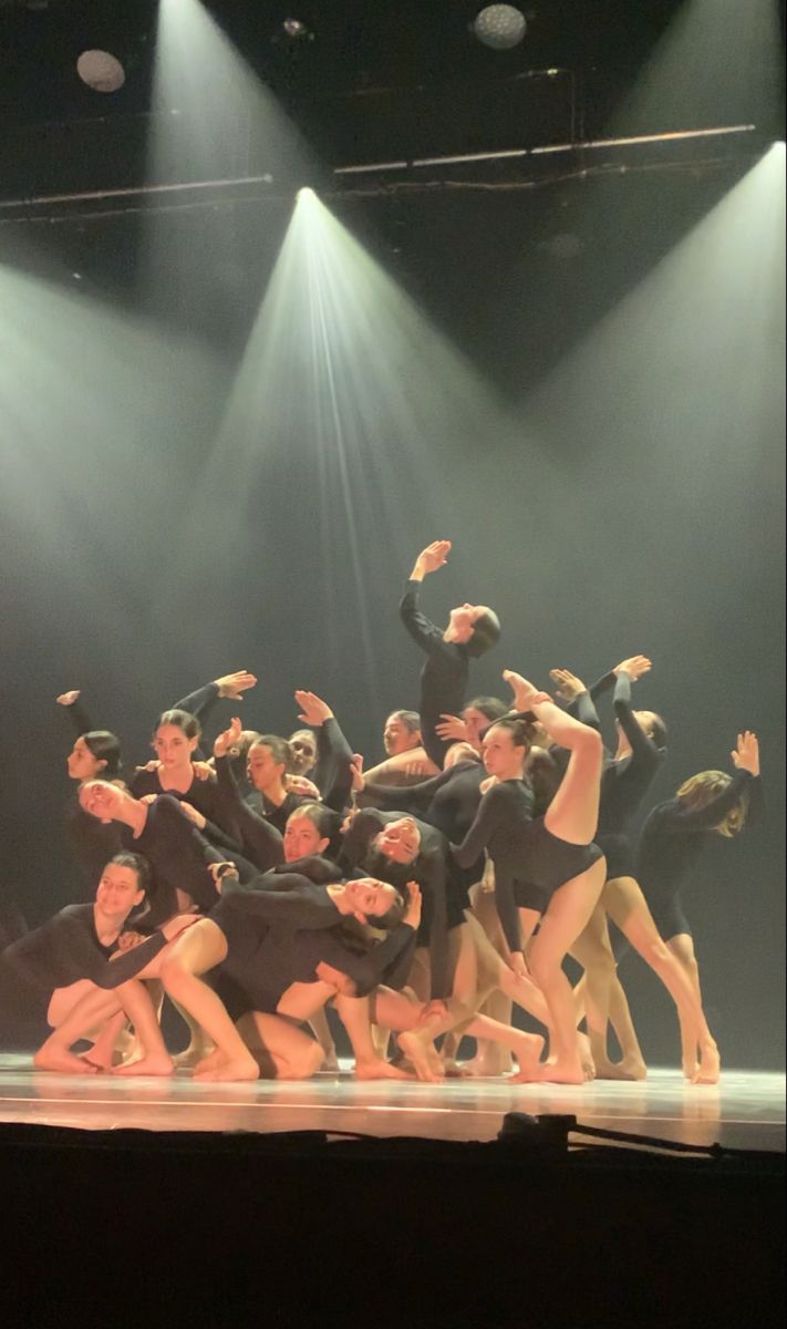 a group of people standing on top of a stage with their arms in the air