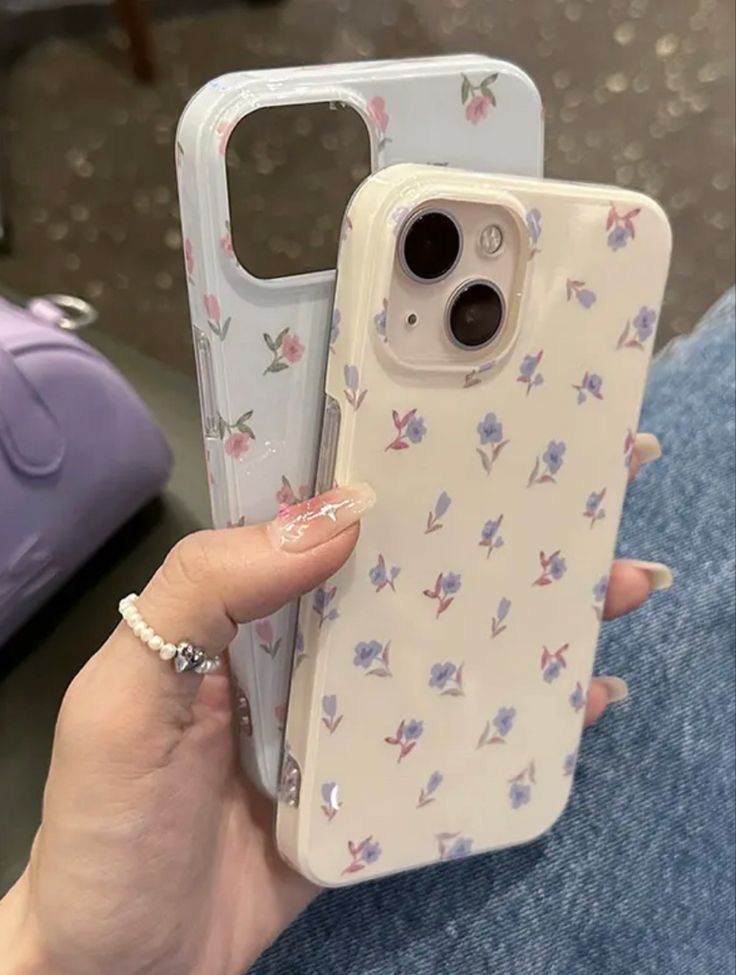 a woman holding an iphone case with flowers on the front and back cover in her hand