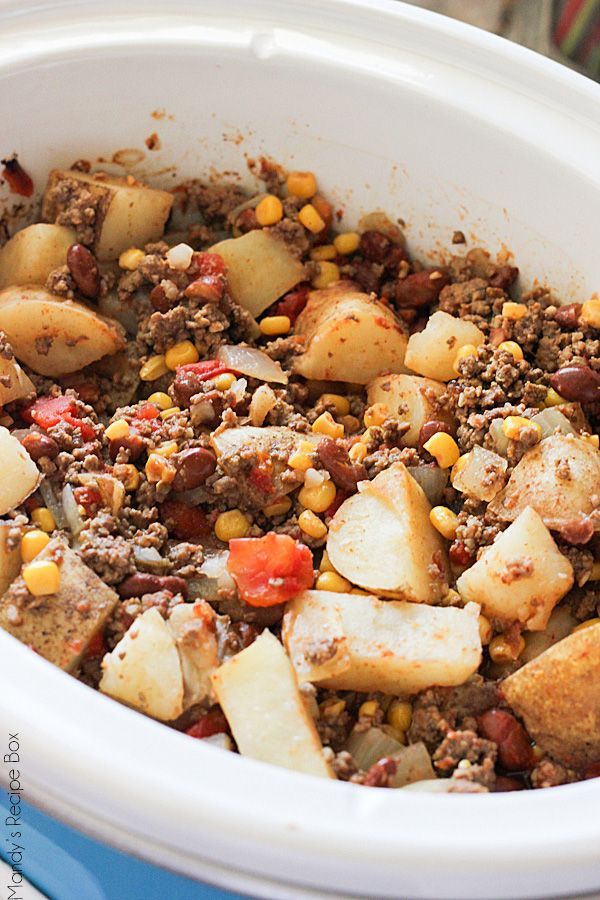 a close up of food in a bowl with potatoes and corn on the side,