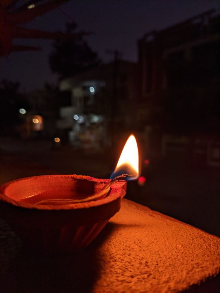 a lit candle sitting on top of a wooden table