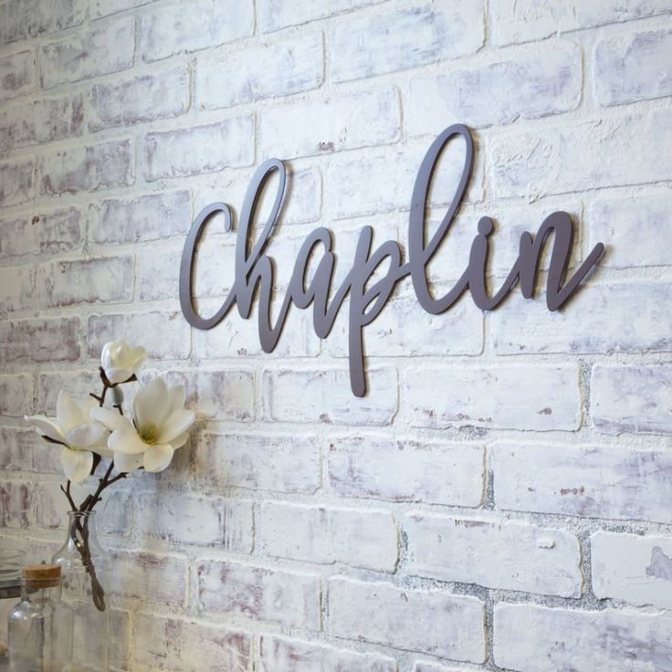 a white brick wall with the word chaplin hanging on it's side