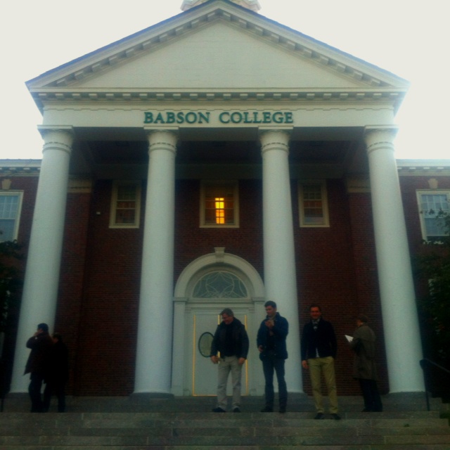 three men standing on steps in front of a building with columns and the words bacon college