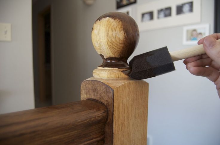 a person holding a hammer near a piece of wood on top of a wooden post