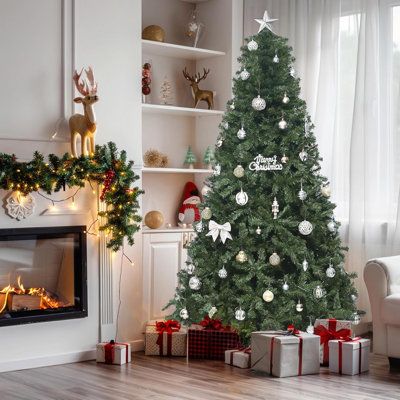 a decorated christmas tree in front of a fireplace with presents on the floor next to it