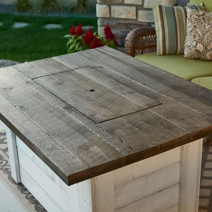 an outdoor table made out of pallet wood with a bench in the back ground