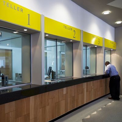 a man is standing in front of the counter at an office cubicle that has yellow and black signs on it