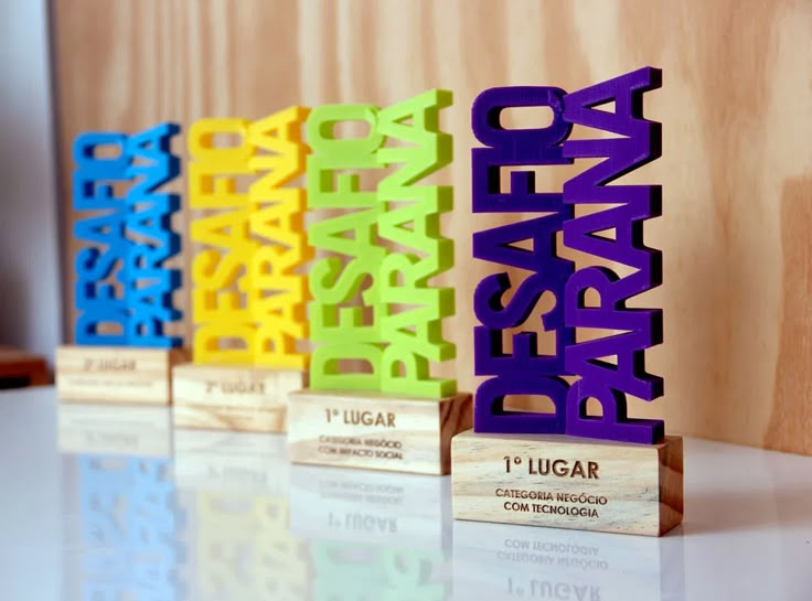 three wooden blocks with the word peace in different colors and sizes are on a table