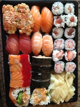 a black tray filled with different types of sushi