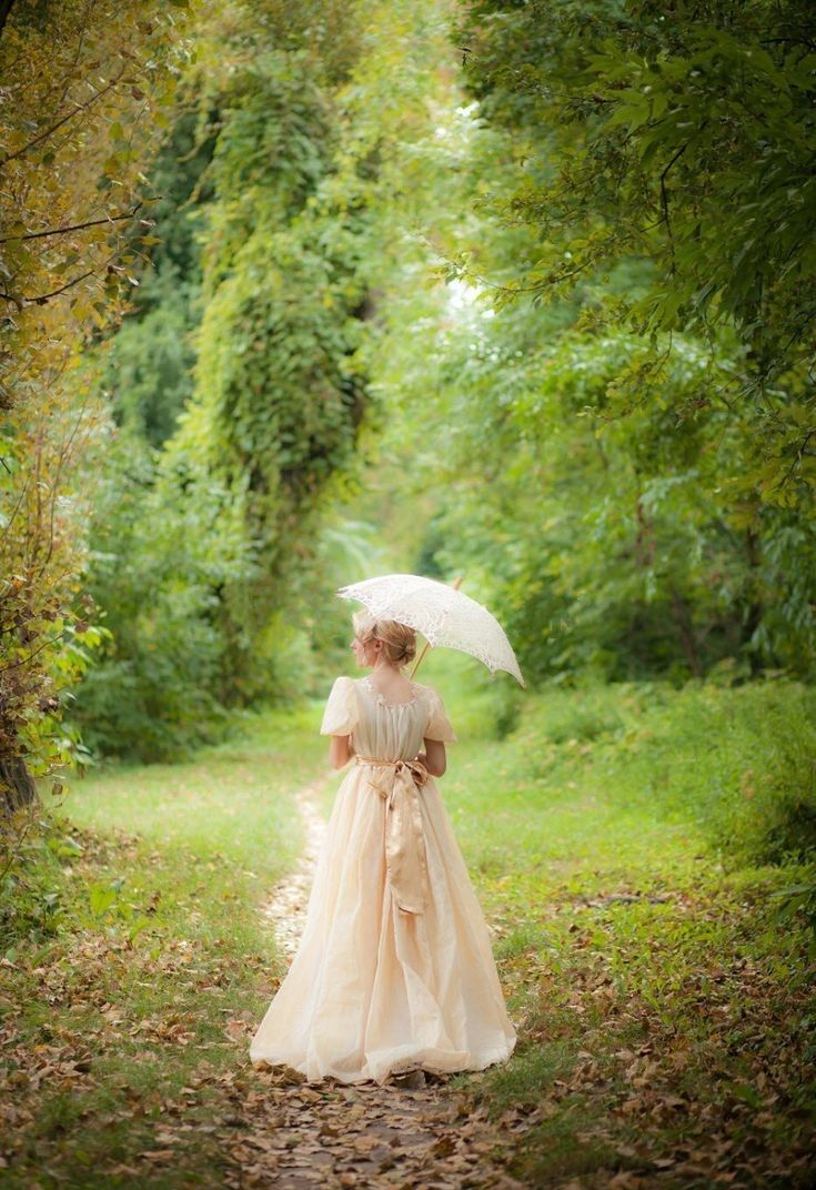 a woman with an umbrella walks through the woods