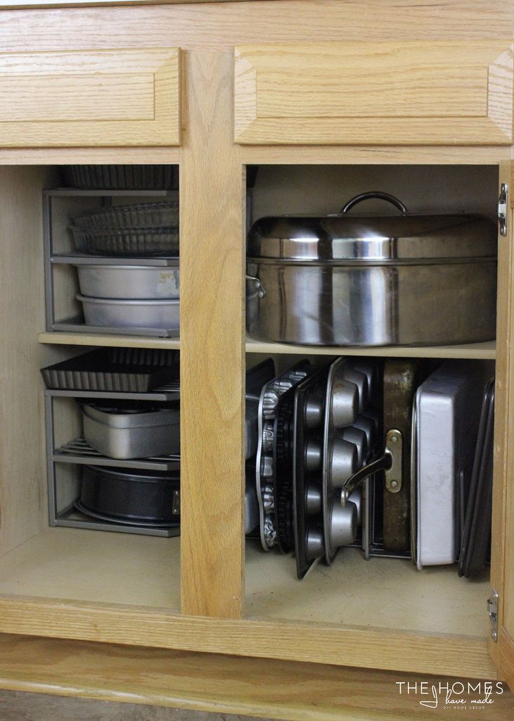 an open cabinet filled with pots and pans